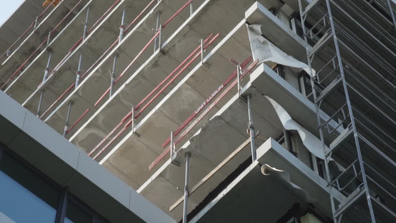 captura de detalle en cámara lenta de un edificio en obras con el viento moviendo un plástico