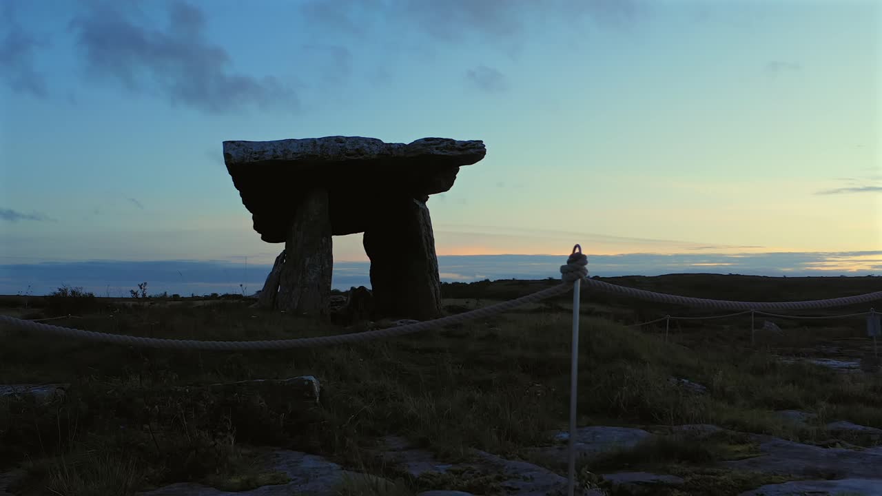 Velbevaret Poulnabrone Dolmen omgivet af reb ved tusmørke med blødt aftenlys