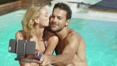 Atractiva-Pareja-Tomando-Selfie-Junto-A-La-Piscina.