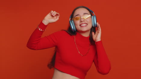 Young-happy-woman-in-headphones-listening-music-dancing-disco-having-fun-relaxing-on-christmas-party