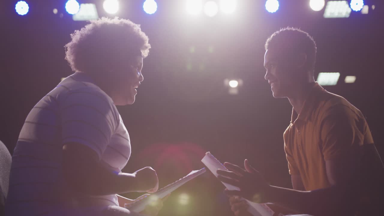 Students preparing before a high school performance in an empty school theater