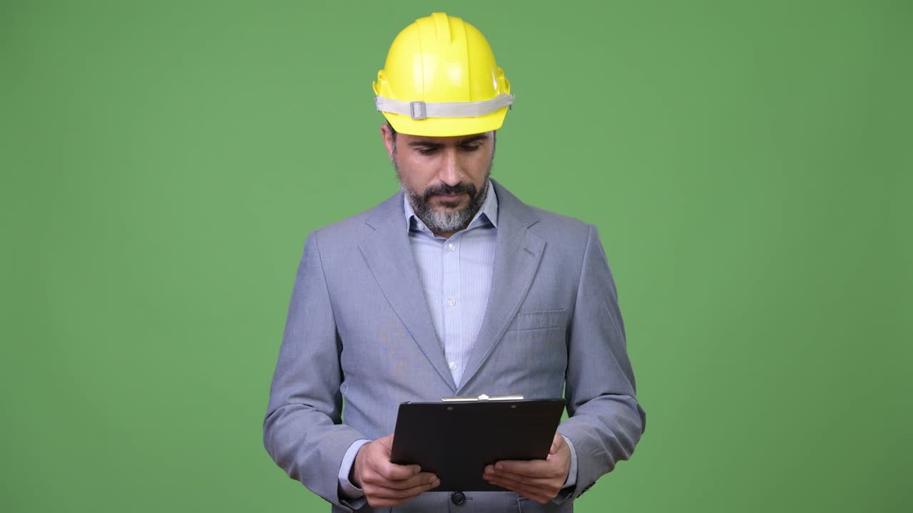 Handsome Persian bearded businessman as engineer thinking with clipboard
