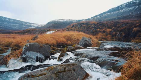 beautiful icelandic waterfall landscape with river and mountains covered by snow in autumn, wilderness of westfjords, dynjandi, iceland