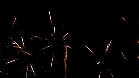 explosiones simultáneas de luces brillantes de colores que llenan el cielo nocturno en una playa de un famoso destino turístico