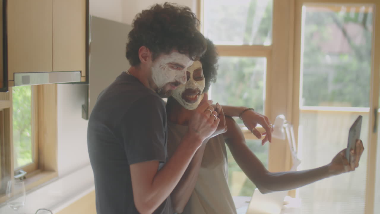 Couple with Clay Masks Taking Selfie at Home