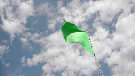 bright green flag waving in the wind on a clear sunny day -close up