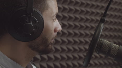 close up of a young man in a radio recording studio listening to the arguments of someone seated next to him