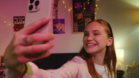 a young woman in a bedroom taking a selfie