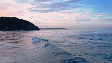 tiro de un dron de un surfista de un surfista atrapando una ola en la playa de berria en cantábrico, españa