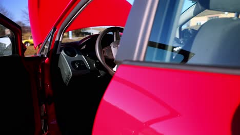 a red vehicle with deployed airbags on the steering wheel after a collision - close up