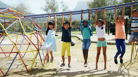 animation of rainbow heart over diverse children playing on playground