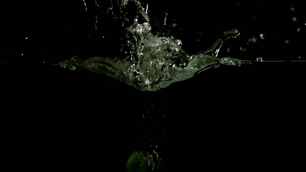 Strawberry falling in water on black background