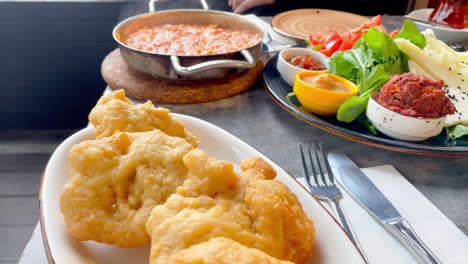 delicious turkish breakfast with menemen, tea and tasty cheese plate