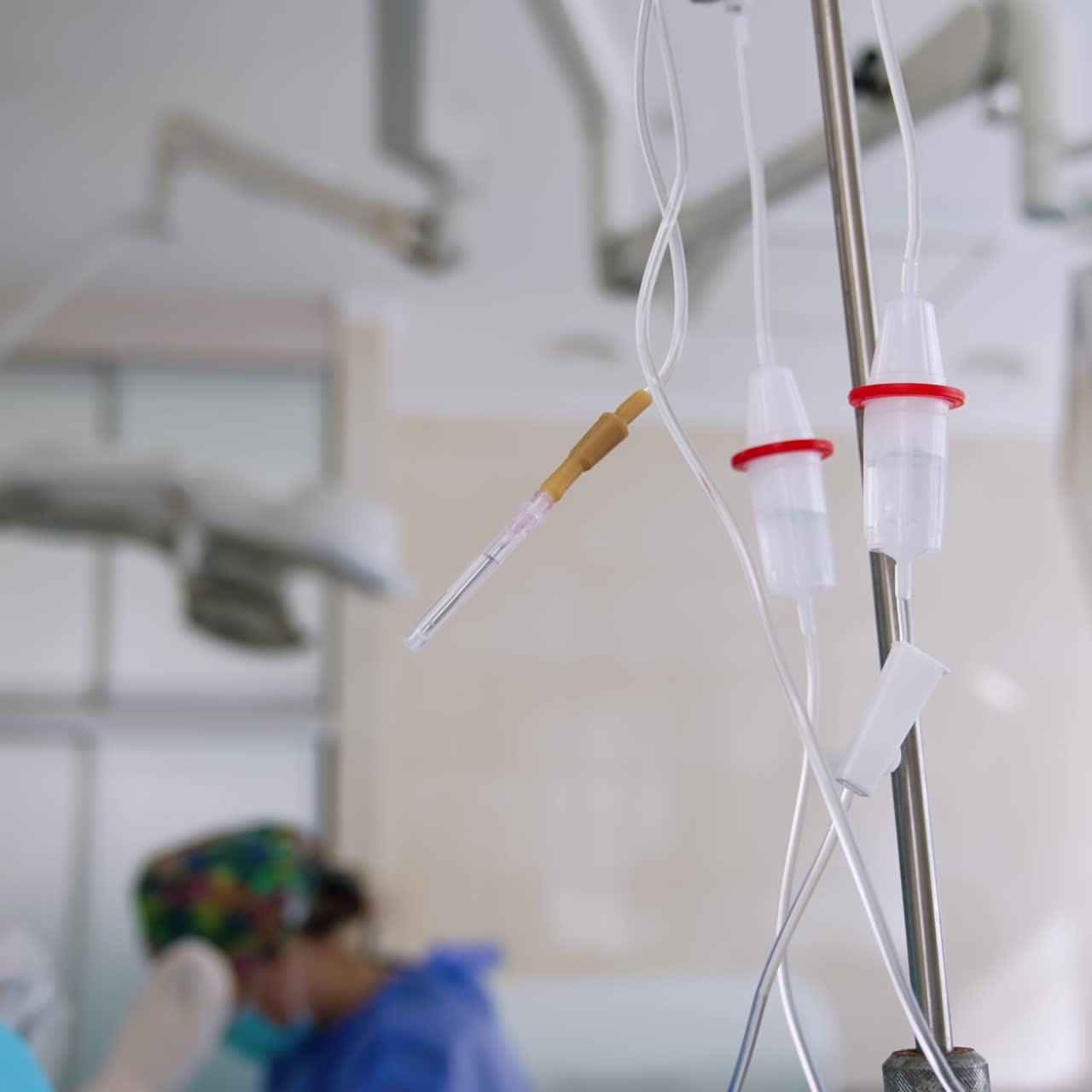 I serbatoi dei contagocce sono appesi al supporto. Primo piano. Medici con mascherine e cuffie lavorano sullo sfondo in modo sfocato.