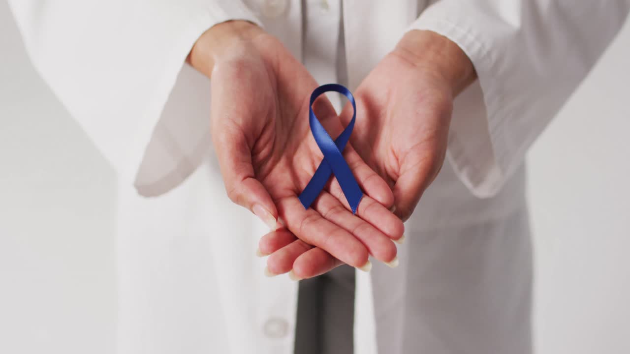 Video di una dottoressa di etnia mista che tiene un nastro viola per il cancro al pancreas