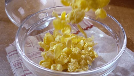 flocos de maíz amarillos crujientes en el cuenco para la mañana un delicioso desayuno con leche. cámara lenta con toma de seguimiento de rotación.