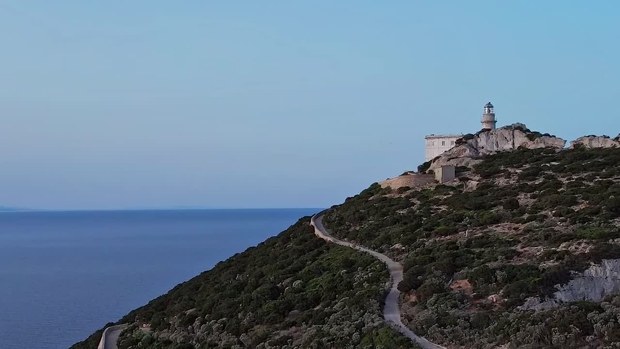 Vista di un faro su una collina con vista sul mare in Sardegna
