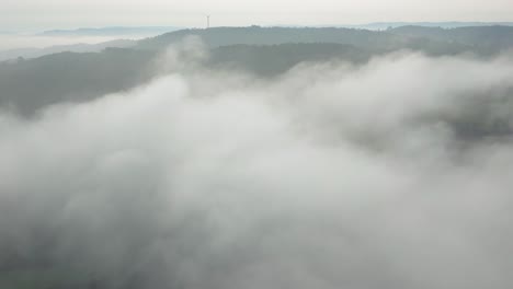 dense clouds canopy over foggy forest mountains