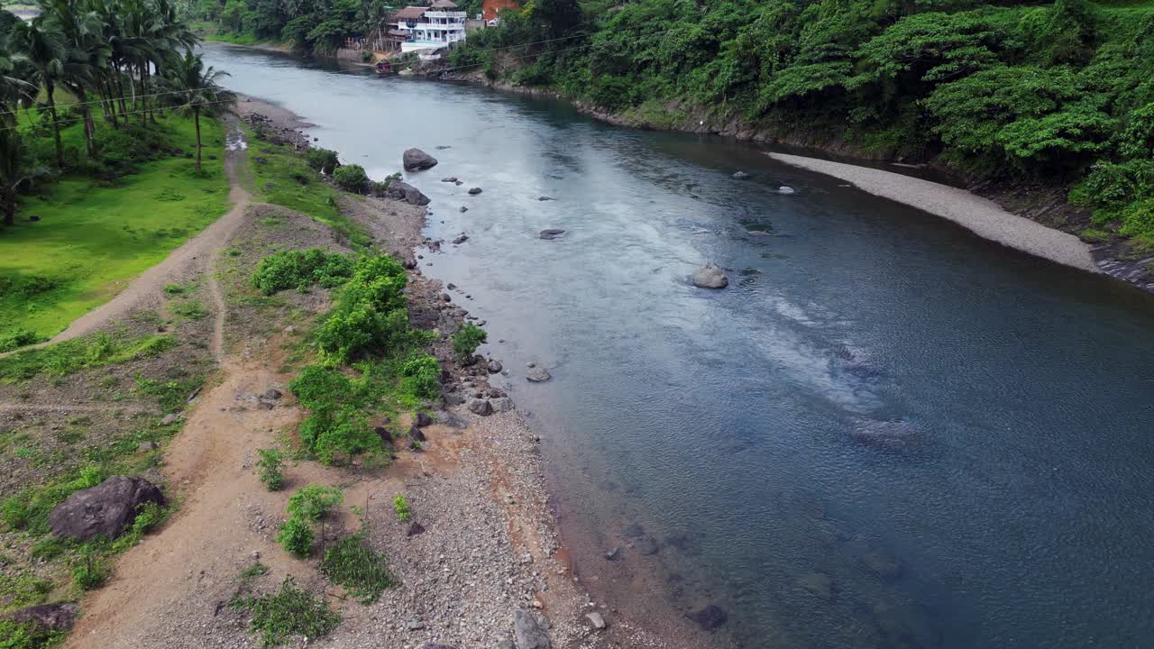 drone descendiendo por encima del agua del río corriendo a través de grandes rocas en filipinas