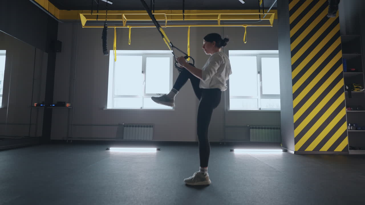 fitness TRX training exercises at gym woman push-up workout. Attractive woman doing exercise for hands in gym. core abs crossfit oblique training with fitness straps in the gym's studio. TRX