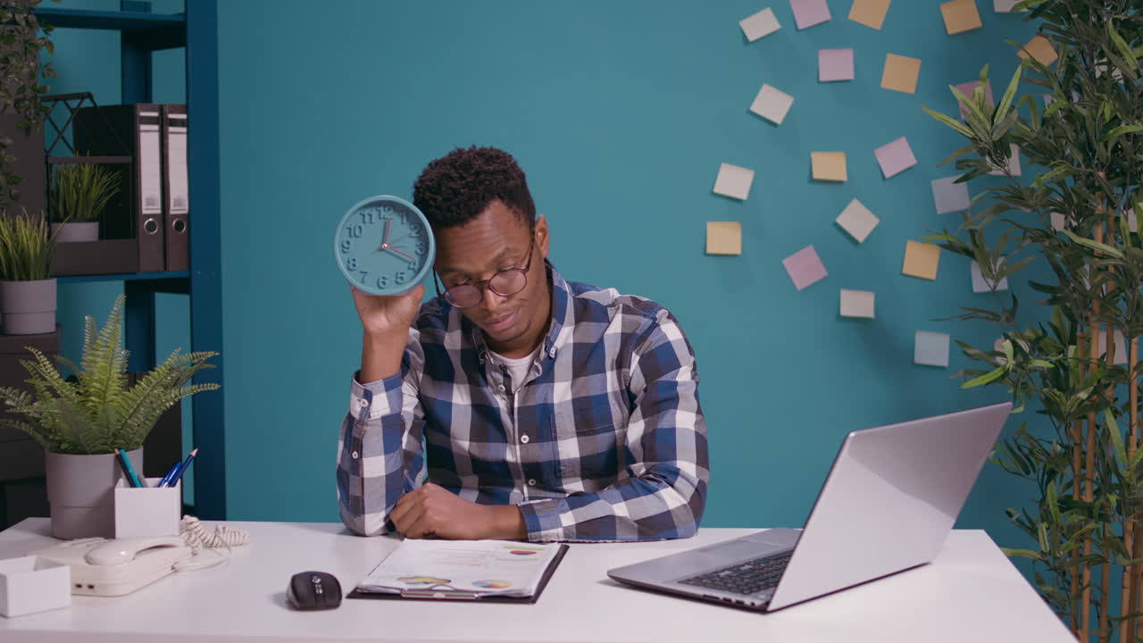 Punctual man checking time on wall clock and feeling upset