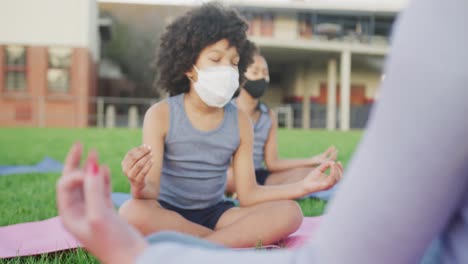 boy wearing face mask performing yoga in the garden