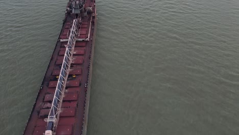 long industrial cargo vessel shipping on detroit river, aerial fly over view