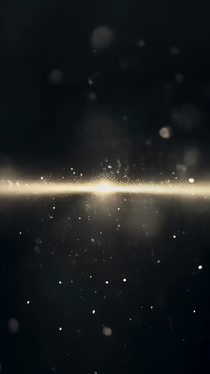 Video verticale: fascia dorata brillante che si illumina e poi svanisce, colonna di polvere che si disperde verso l'alto in studio, bokeh