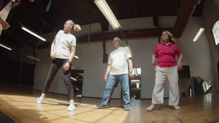 Long shot of excited senior people learning dance combination