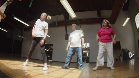 long shot of excited senior people learning dance combination