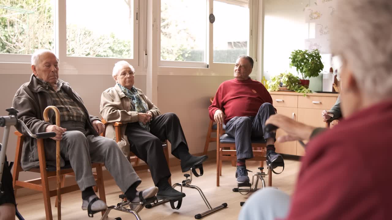Senior people exercising with bike pedals in retirement home
