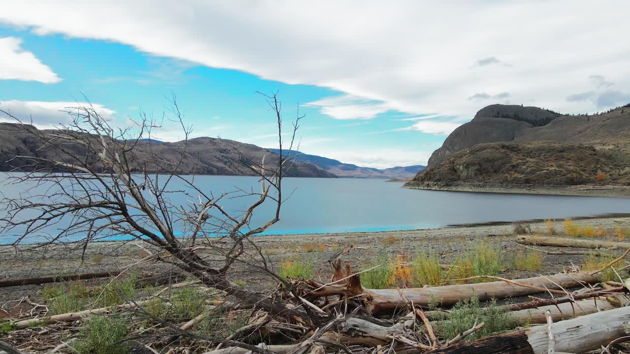 empuje en tiro sobre tocones de árboles quemados hacia el lago kamloops en un día parcialmente nublado en el otoño en un paisaje desértico en la región de nicola thompson en bc canada