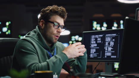 Tensed coder solving problem in dark datacenter closeup. Tired man working late