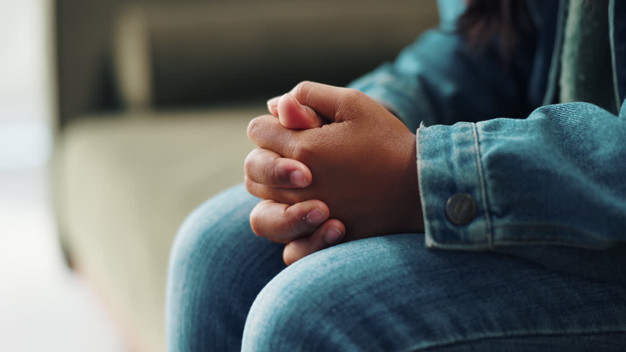 Close up of hands clasped in denim