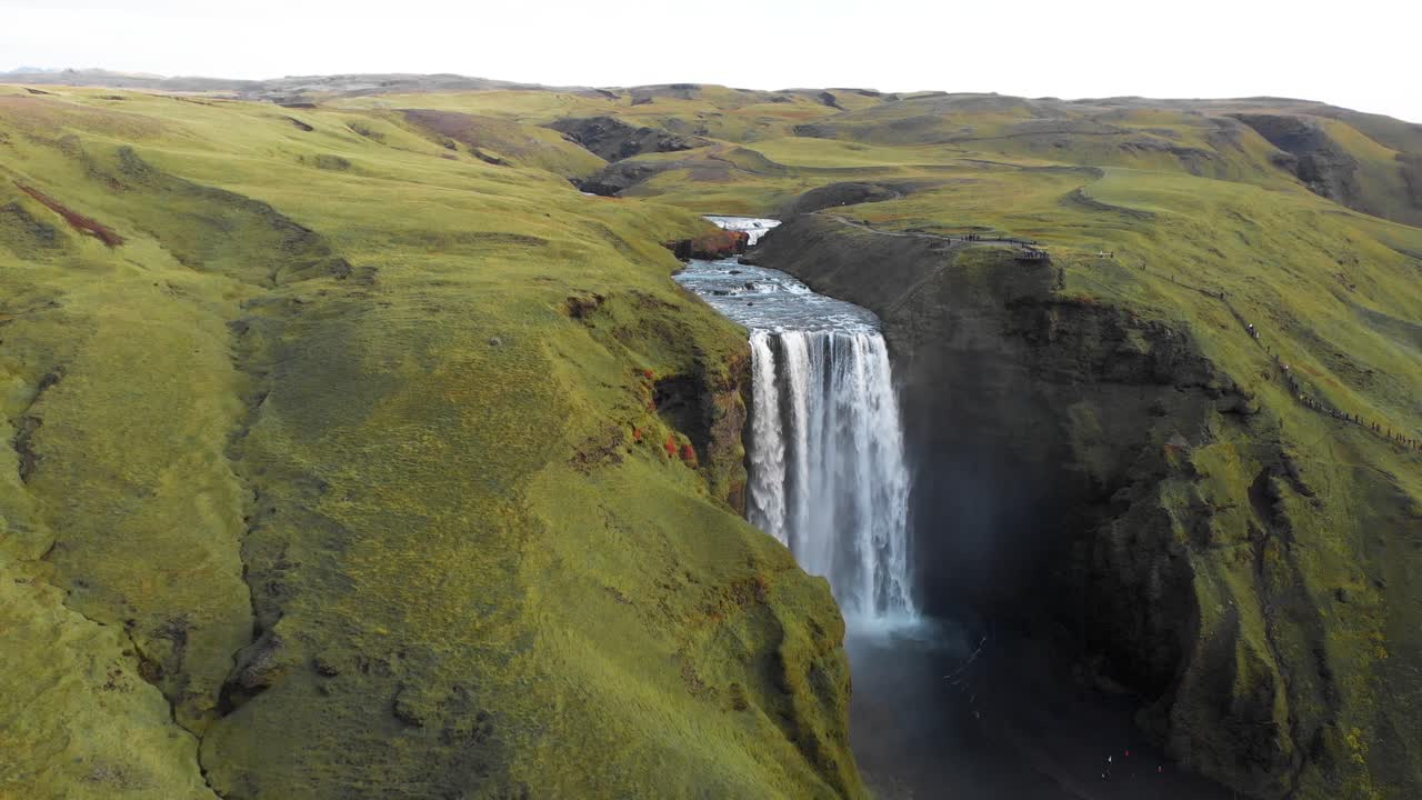 el impresionante paisaje de la cascada de skogafoss con colinas verdes en islandia