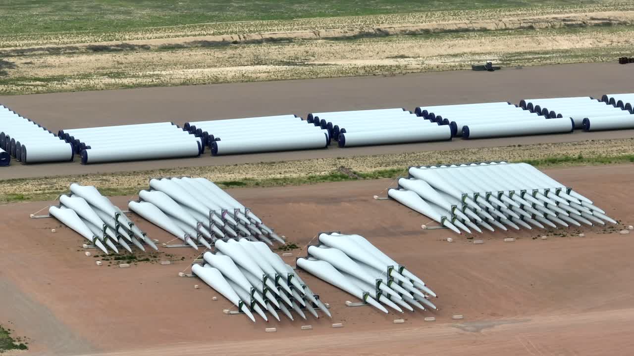 Pale di turbine eoliche e componenti in attesa di assemblaggio e installazione in un parco eolico.