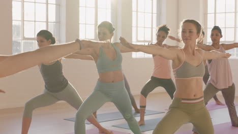 Yoga-Klasse,-Multiethnische-Frauen,-Die-Kriegerpose-Praktizieren-Und-Einen-Gesunden-Lebensstil-Genießen-Und-Bei-Sonnenaufgang-Im-Fitnessstudio-Trainieren