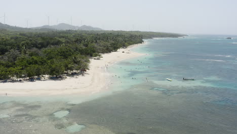 turistas nadando en un mar azul poco profundo en playa teco maimon, una playa turística de arena blanca en la república dominicana