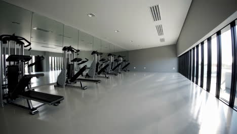 empty modern gym with exercise equipment and large windows