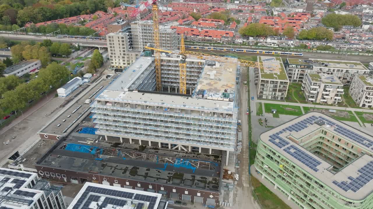 Aerial approach yellow crane on construction site working on new building for new residential area
