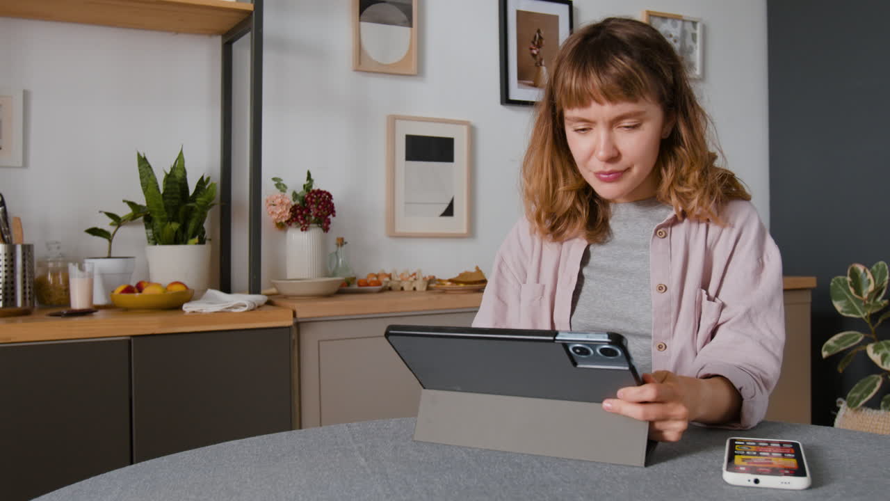 женщина использует планшет на кухне