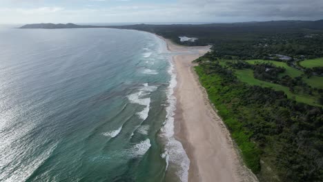 Océano-Idílico-Y-Exuberante-Vegetación-En-La-Playa-De-Pertenencia-En-Byron-Bay,-Nueva-Gales-Del-Sur,-Australia---Toma-Aérea