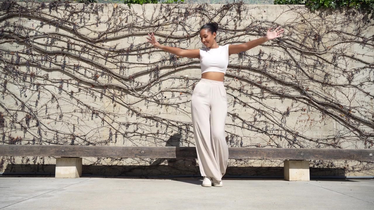 A stylish and fashionable dance pose set against a vibrant artistic and colorful wall background