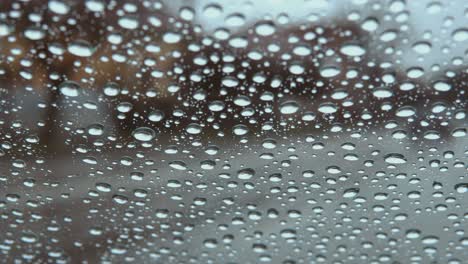 rain drops on car window glass with blurred city car lights bokeh as