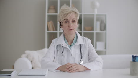 telemedicine session with aged woman therapist pediatrician or virologist doctor is talking to camera like in videochat or videocall