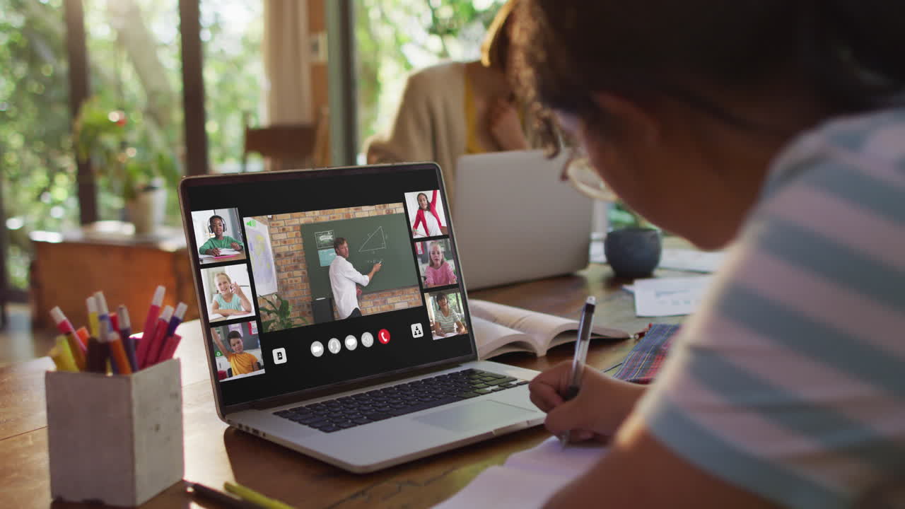 estudiante que usa una computadora portátil para una lección en línea en casa, con un maestro y una clase diversos en la pantalla