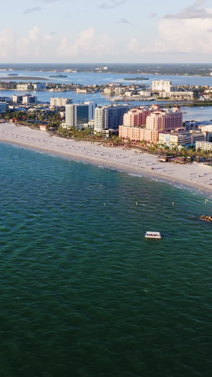 A panoramic view of beachfront resorts and city hotels rises behind a ...