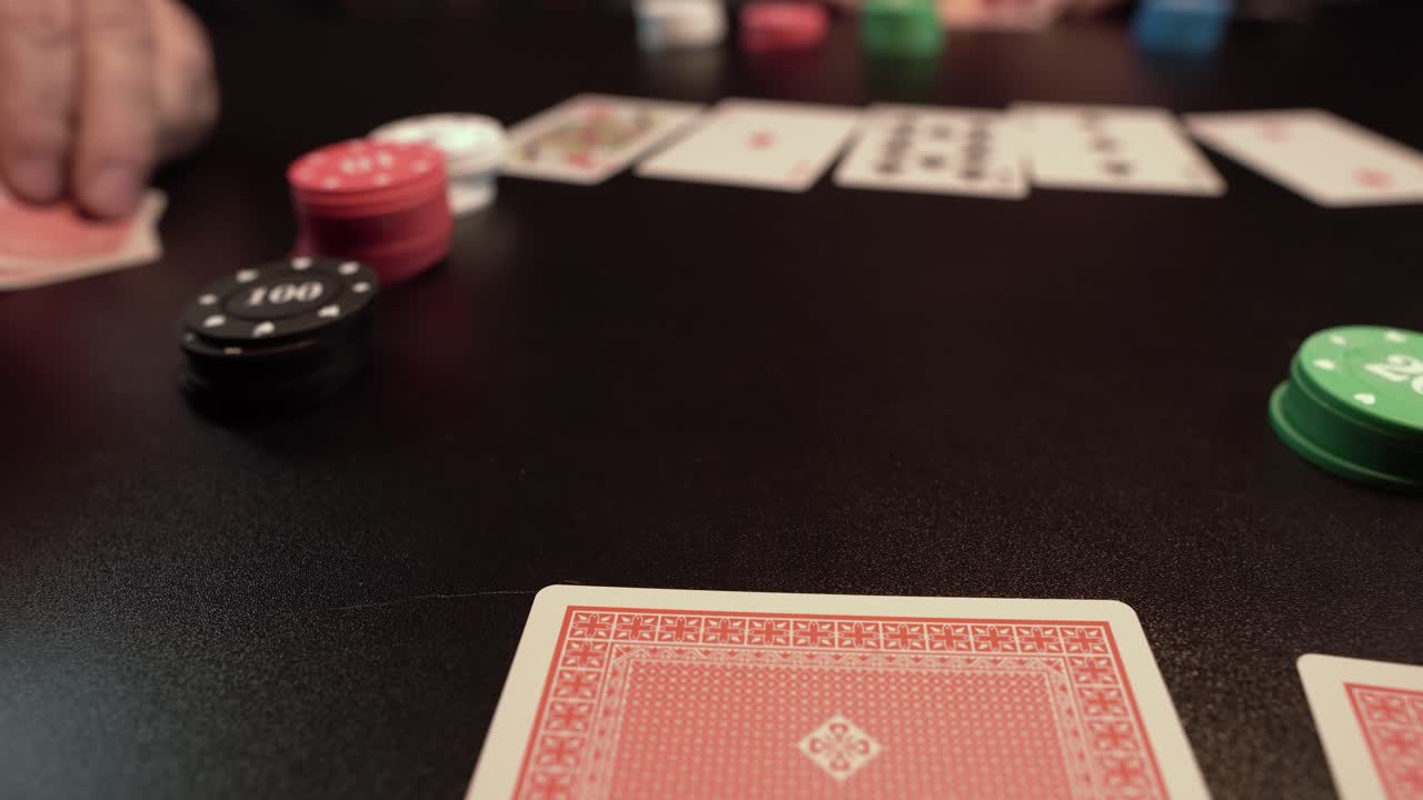 Partita di poker Texas Hold'em, carte e fiches sul tavolo, primo piano.