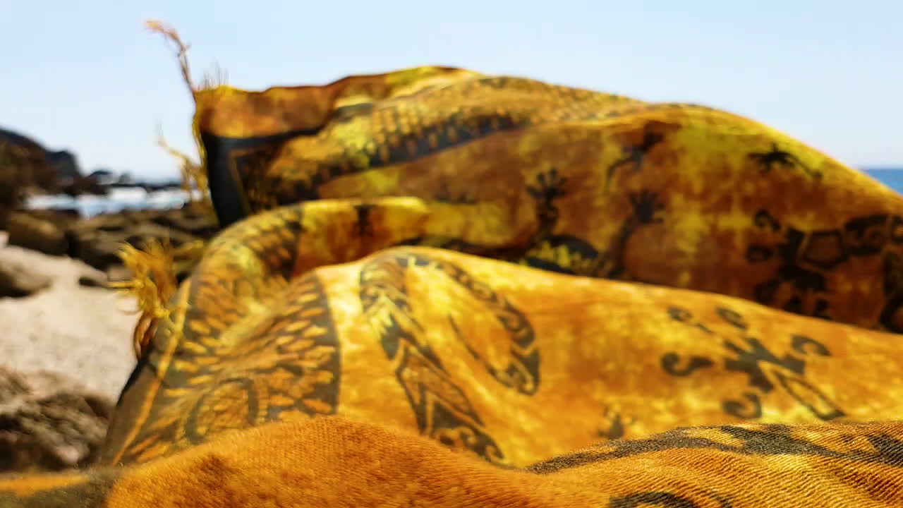 foque en cámara lenta desde una toalla colorida hasta una hermosa costa