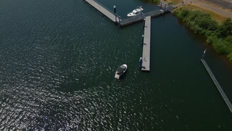 Aerial-birdseye-shot-of-De-Grote-Hegge-in-Thorn,-Maasgouw-in-the-province-of-Limburg-overlooking-the-calm-lake-with-a-jetty-and-boat-in-the-water